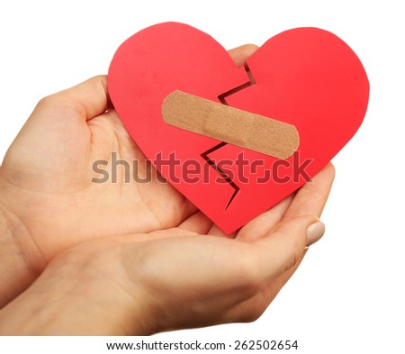 Female hands holding broken heart with plaster isolated on white