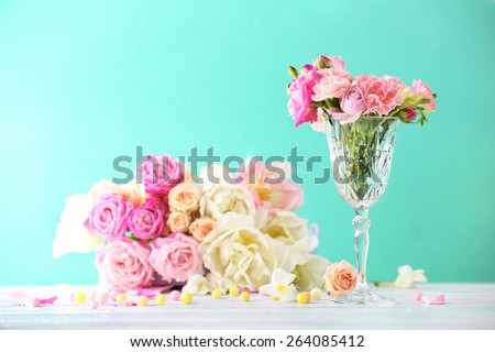 Beautiful spring flowers in glass vase on light blue background