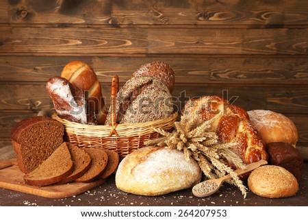 Different bread with ears and sunflower seeds on wooden background