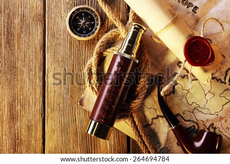 Marine still life spyglass, rope, pipe and world map on wooden background