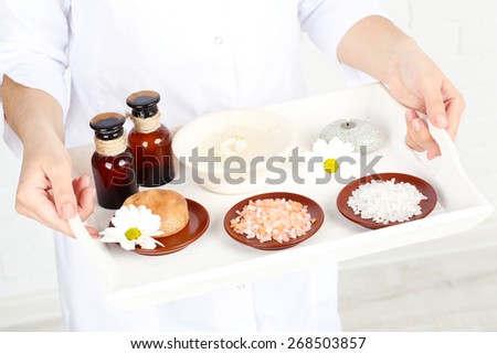 Beauty therapist holding tray of spa treatments, close-up