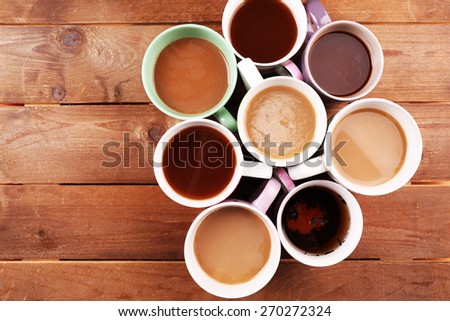Cups of cappuccino on wooden table, top view