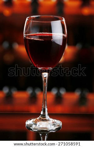 Glass of red wine on bar background