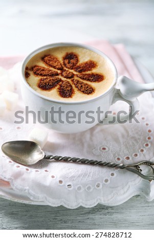 Cup of latte coffee art on wooden table, on light background