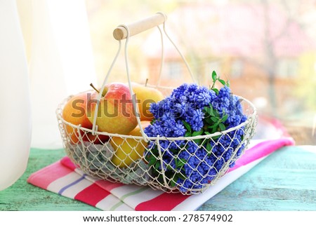 Beautiful bouquet of muscari - hyacinth with fruits in metal basket on windowsill