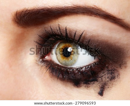 Eye of young woman with tear drop close up
