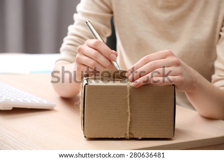 Woman signs parcel in post office