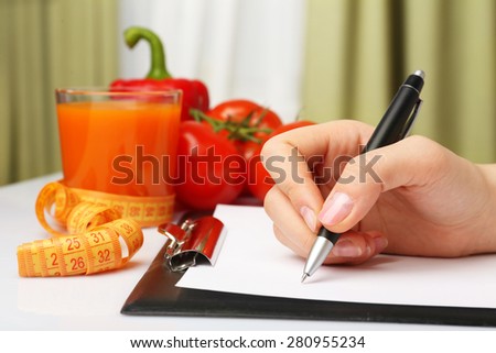 Nutritionist Doctor writing  diet plan in office, closeup