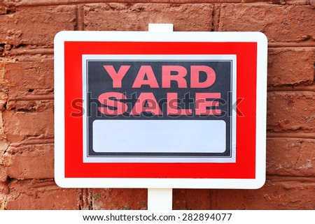 Wooden Yard Sale sign on red brick wall background