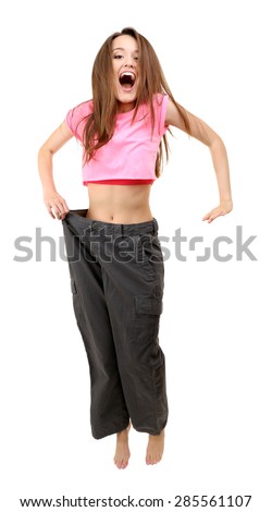 Young slim woman wearing too big pats isolated on white
