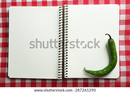 Open recipe book on color tablecloth background