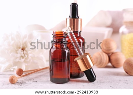Spa dropper bottles with essence on wooden table, closeup