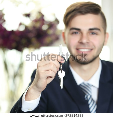 Portrait of businessman with keys in hand in office