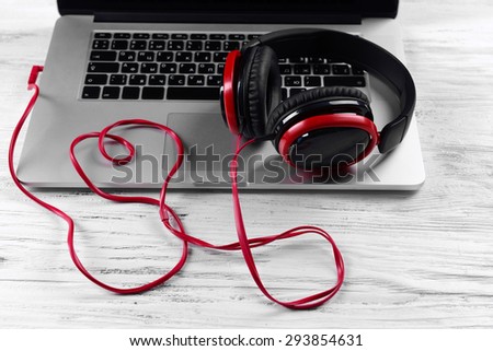 Headphones with laptop on table close up