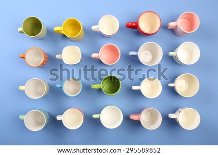 Group of colorful cups on color table, top view