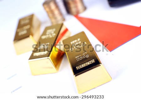 Gold bullion with coins on documents background