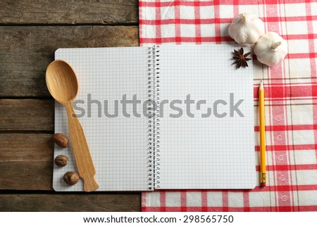 Open recipe book on napkin, on wooden background