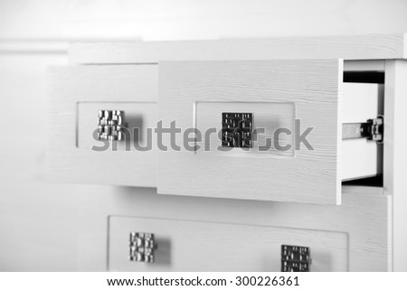 White wooden chest of drawer, close up. Open drawer