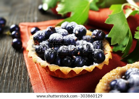Delicious crispy tarts with black currants on red napkin, closeup