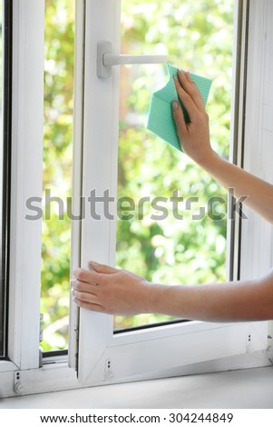 Woman washing window in room