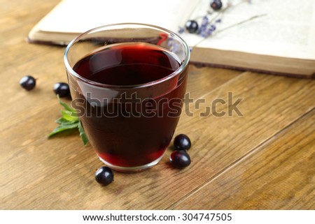 Fresh currant juice with berries and book on table close up
