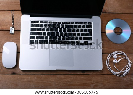 Workplace with laptop and other computer accessories on wooden background