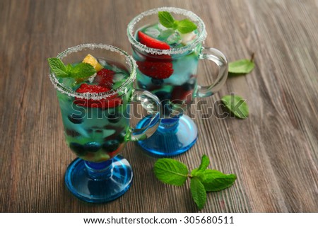 Glasses of berries juice on wooden background