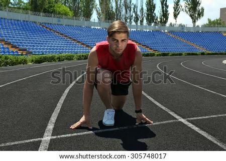 Runner in start position on stadium