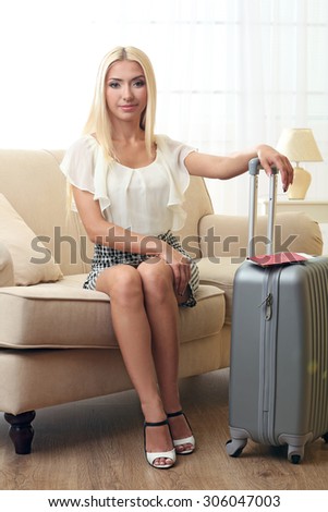 Woman with suitcase after traveling at home