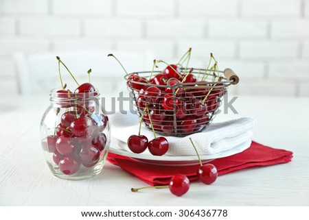Cherries in basket on table, on light background