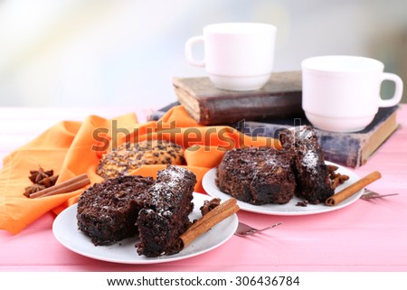 Delicious chocolate roll on wooden table with orange napkin and books ,closeup