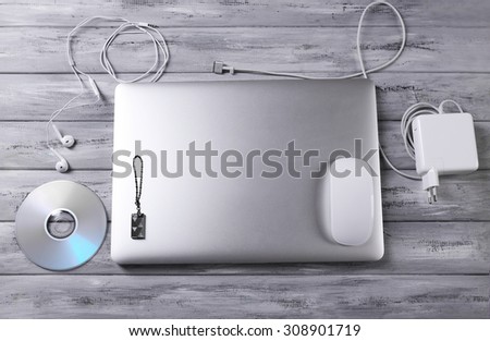 Workplace with laptop and other computer accessories on wooden background
