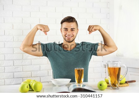 Young strong man having light breakfast