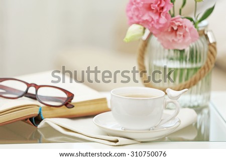 Cup of coffee with book on table in living room