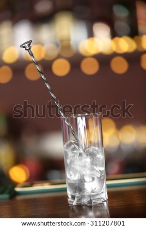 Glass with ice on bar counter