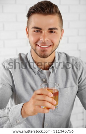 Young man showing glass of apple juice
