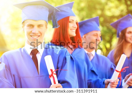Graduated students in graduation hats and gowns, outdoors