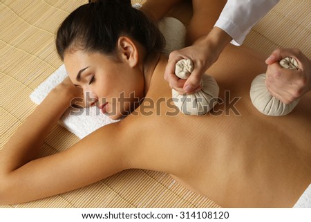 Young woman enjoying back massage in beauty spa salon
