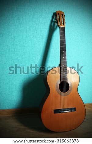 Classical guitar on turquoise wallpaper background