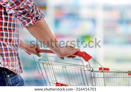 Young man with shopping cart in store