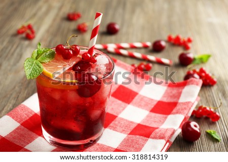 Glass of berry juice on wooden table, closeup