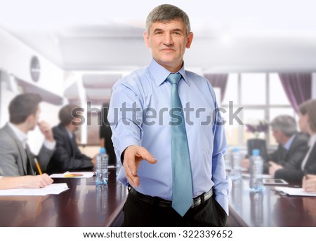 Businessman giving his hand for a handshake and business people