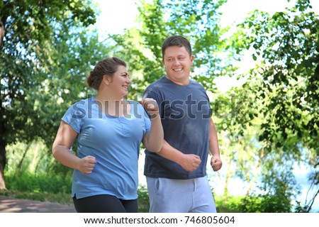 Overweight couple running in green park Foto stock © 