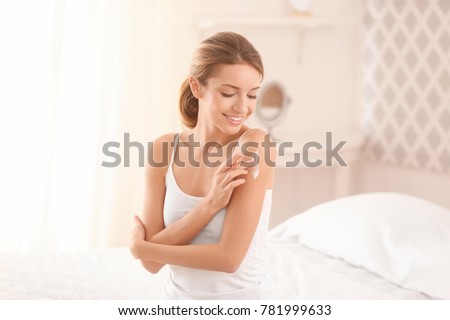 Young woman applying body cream at home ストックフォト © 