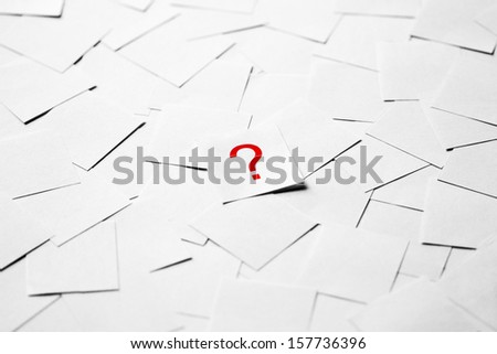 Note paper with question mark on a pile of blank papers