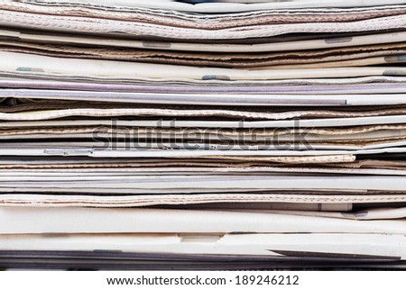 Closeup texture of newspapers stack. Abstract background. Breaking news, journalism,  newspaper and magazine ads and subscription concept. Great as a web page banner, article illustration and more.