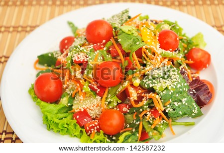 Salad with cherry tomatoes and sesame seeds.