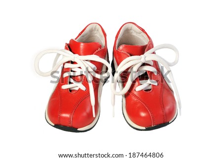 Pair of children\'s shoes on the red cord on a white background.