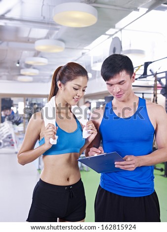 young woman talking to her trainer about her training plan.