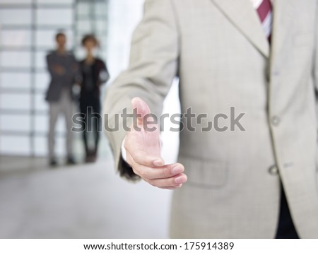 businessman reaching out for a handshake.